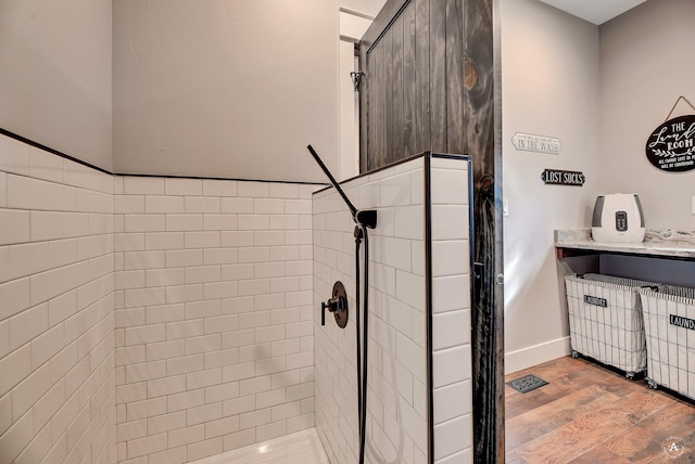 bathroom featuring tiled shower and hardwood / wood-style floors