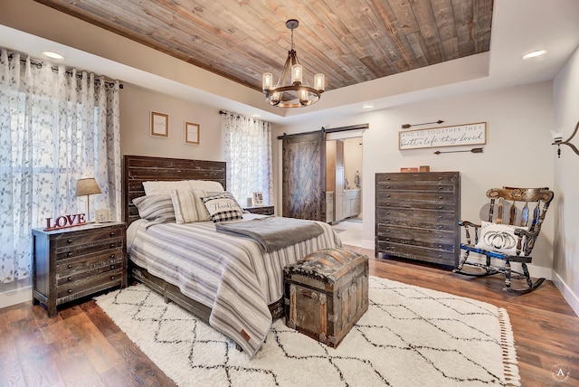 bedroom featuring wooden ceiling, a raised ceiling, a barn door, a notable chandelier, and hardwood / wood-style floors