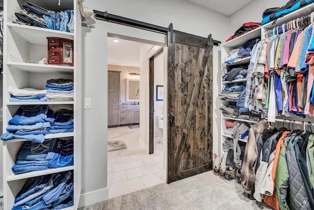 spacious closet with tile patterned floors and a barn door