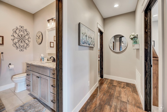 bathroom with hardwood / wood-style floors, vanity, and toilet