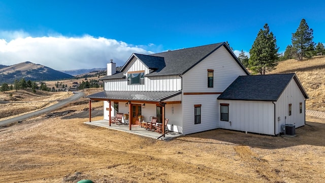 rear view of property featuring a mountain view, cooling unit, and a patio