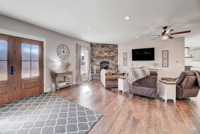 living room with ceiling fan, a fireplace, and hardwood / wood-style flooring