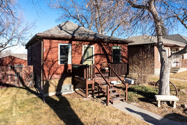 rear view of house featuring a yard