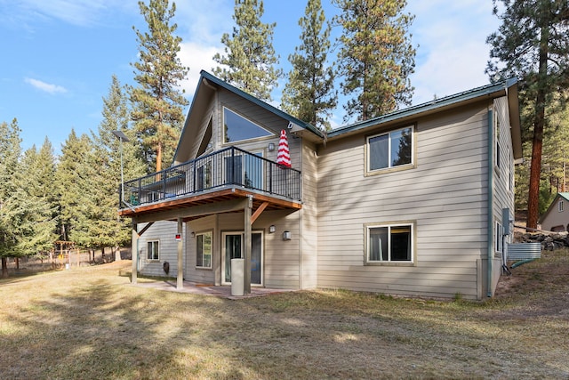 back of property with a yard and a patio