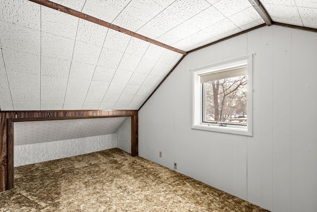 bonus room with wood walls, carpet, and vaulted ceiling