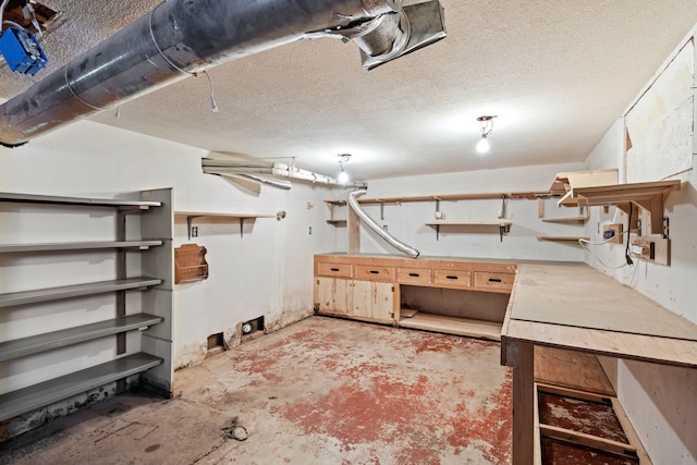 basement with a workshop area and a textured ceiling