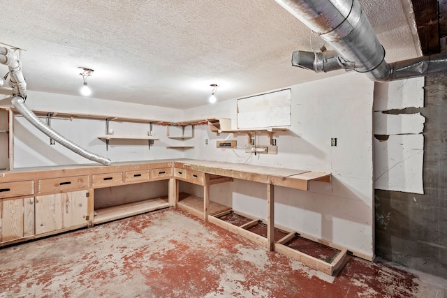 basement featuring a textured ceiling and a workshop area