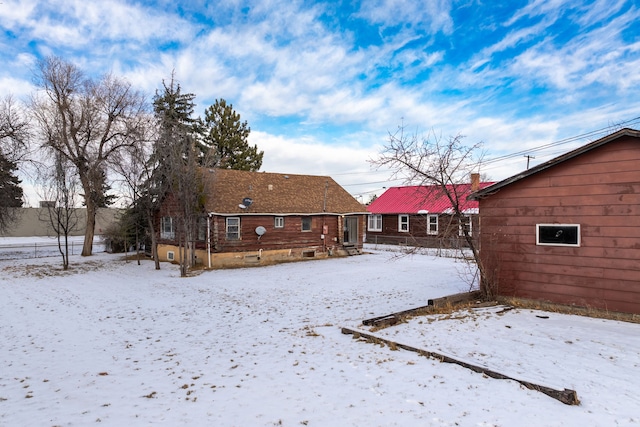 view of snow covered back of property