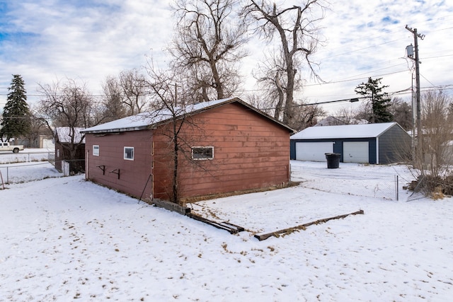 exterior space with a garage and an outbuilding