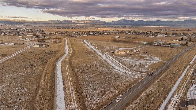 aerial view at dusk featuring a rural view and a mountain view