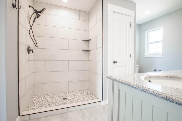 bathroom featuring a tile shower and vanity