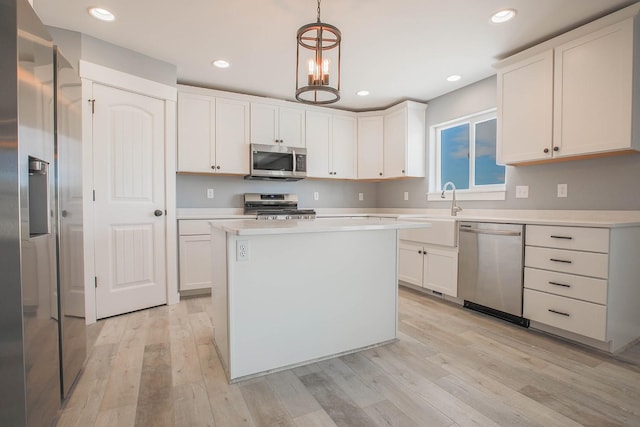 kitchen with stainless steel appliances, white cabinetry, pendant lighting, and a center island