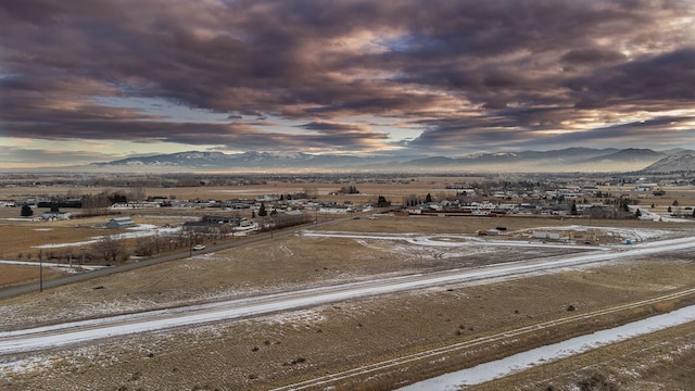 aerial view at dusk featuring a rural view and a mountain view