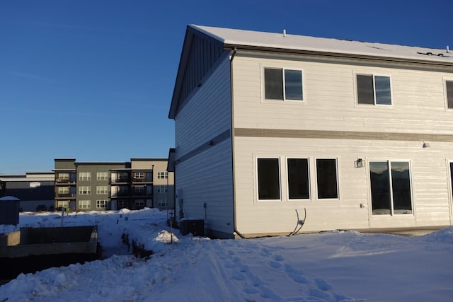 snow covered property featuring central AC