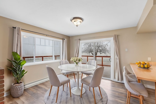 dining room featuring hardwood / wood-style floors and a baseboard heating unit