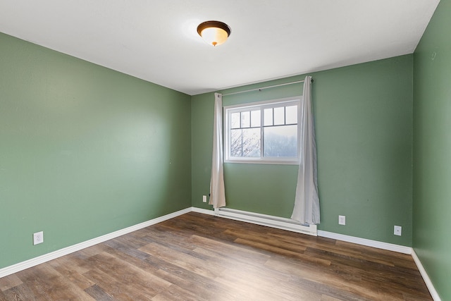 spare room featuring dark hardwood / wood-style flooring and a baseboard radiator