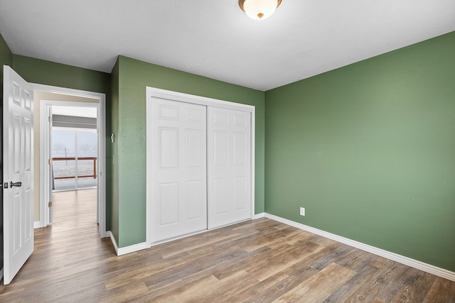 unfurnished bedroom with wood-type flooring and a closet