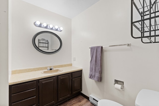 bathroom featuring vanity, a baseboard radiator, toilet, and hardwood / wood-style flooring