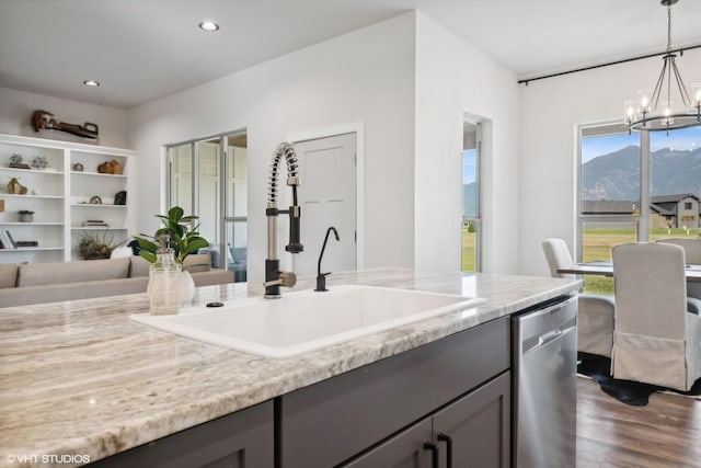 kitchen featuring light stone countertops, dark hardwood / wood-style floors, dishwasher, a chandelier, and hanging light fixtures