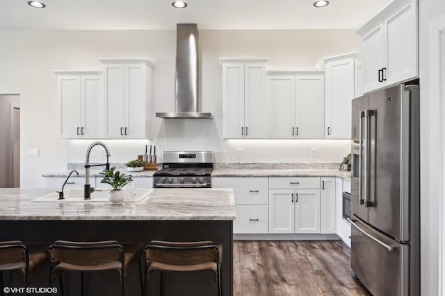 505 Sweetgrass Ranch Rd, Kalispell, MT 59901 - kitchen featuring stainless steel appliances, wall chimney range hood, white cabinets, a breakfast bar area, and light stone countertops
