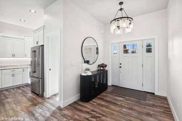 entryway with a chandelier and dark wood-type flooring