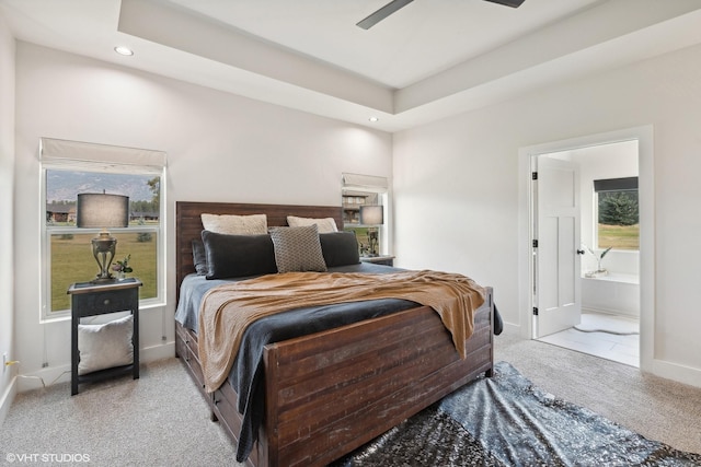 carpeted bedroom with ensuite bath and ceiling fan