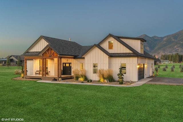 view of front of house featuring a mountain view, a yard, and a garage