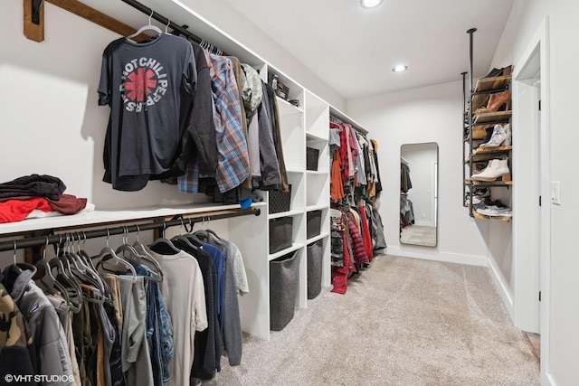 walk in closet with light carpet