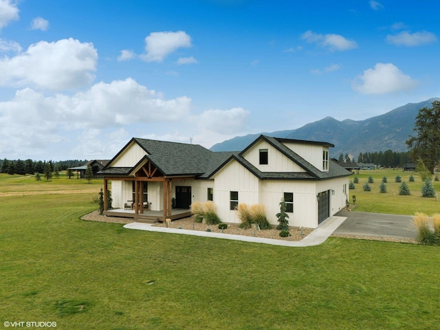 rear view of property with a mountain view and a yard