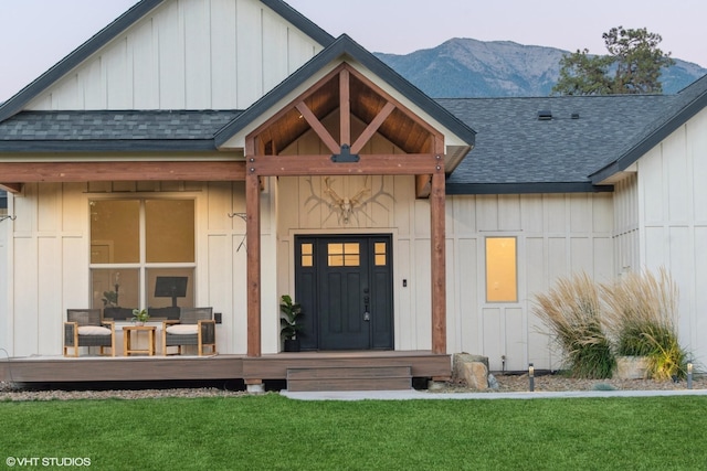 505 Sweetgrass Ranch Rd, Kalispell, MT 59901 - property entrance featuring a shingled roof, a yard, a mountain view, and board and batten siding