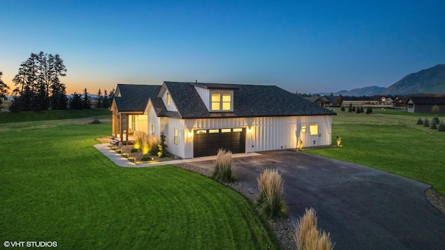 view of front of home featuring a mountain view, a garage, and a lawn