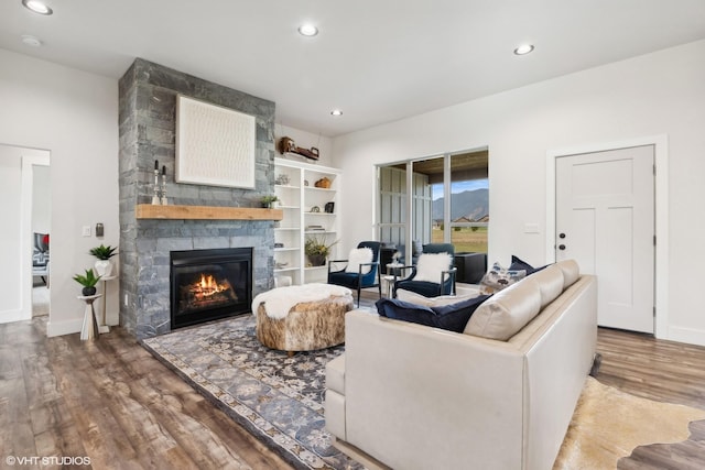 living room featuring hardwood / wood-style floors and a stone fireplace