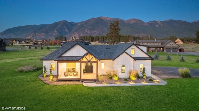 view of front of house featuring a mountain view and a front lawn