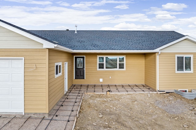 rear view of property featuring a garage