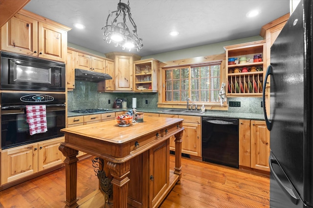 kitchen with butcher block countertops, under cabinet range hood, black appliances, open shelves, and a sink