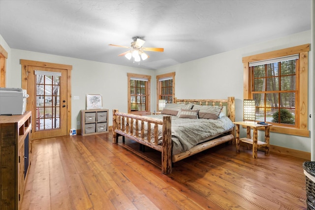 bedroom featuring ceiling fan, light wood-style flooring, and baseboards