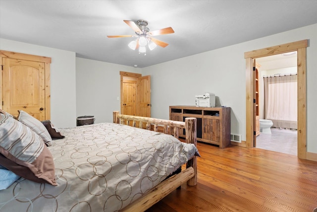 bedroom with light wood-style floors, visible vents, connected bathroom, and a ceiling fan