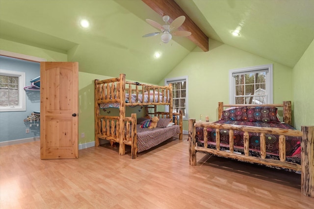 bedroom with multiple windows, vaulted ceiling with beams, baseboards, and wood finished floors