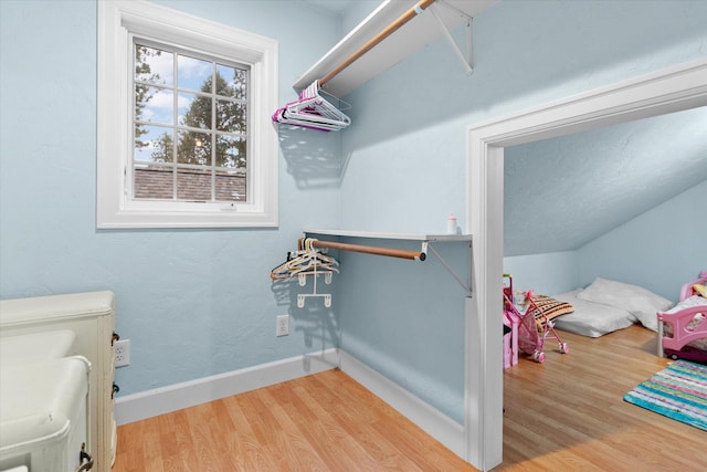 spacious closet featuring vaulted ceiling and wood finished floors