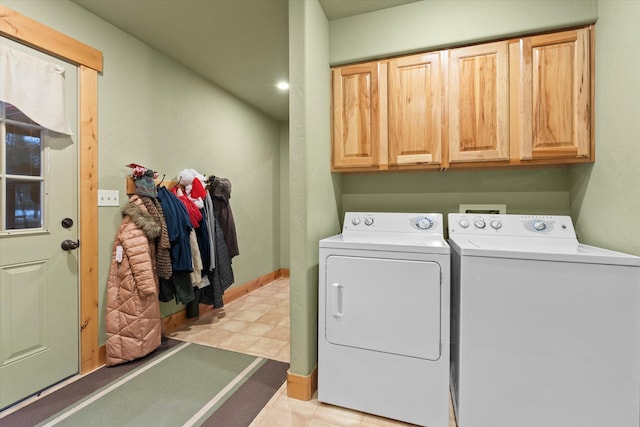 clothes washing area with light floors, independent washer and dryer, cabinet space, and baseboards