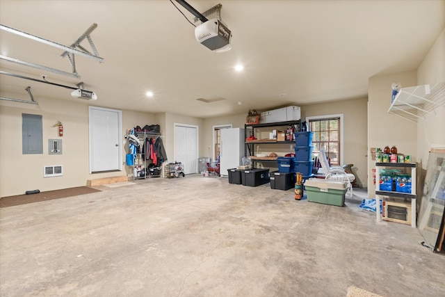 garage featuring recessed lighting, electric panel, and a garage door opener