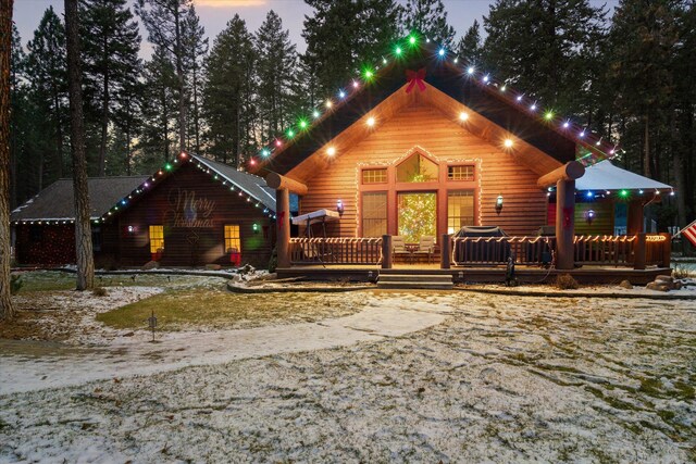 snow covered rear of property featuring a patio area