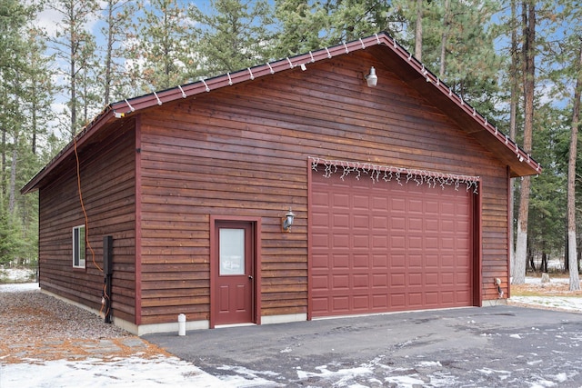 view of side of property with a detached garage and an outbuilding