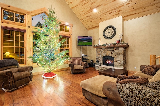 living area featuring wood ceiling, high vaulted ceiling, a stone fireplace, and hardwood / wood-style flooring