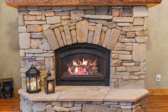 room details featuring a warm lit fireplace and a textured wall