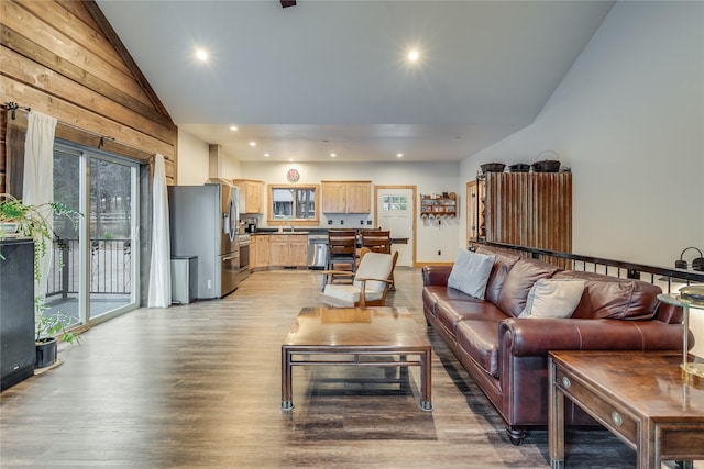 living room featuring sink, high vaulted ceiling, and light wood-type flooring