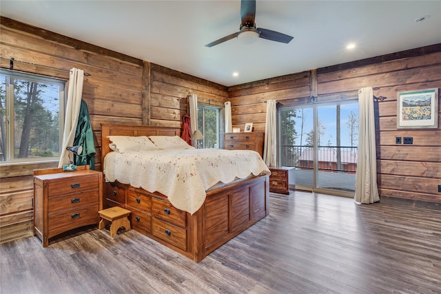 bedroom featuring dark hardwood / wood-style floors, ceiling fan, and multiple windows