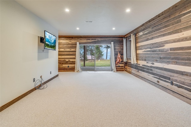 unfurnished living room with carpet flooring and wood walls