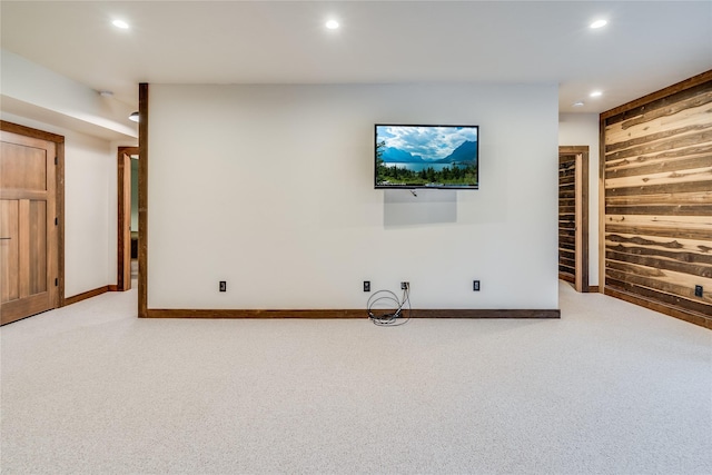 unfurnished living room with carpet and wooden walls