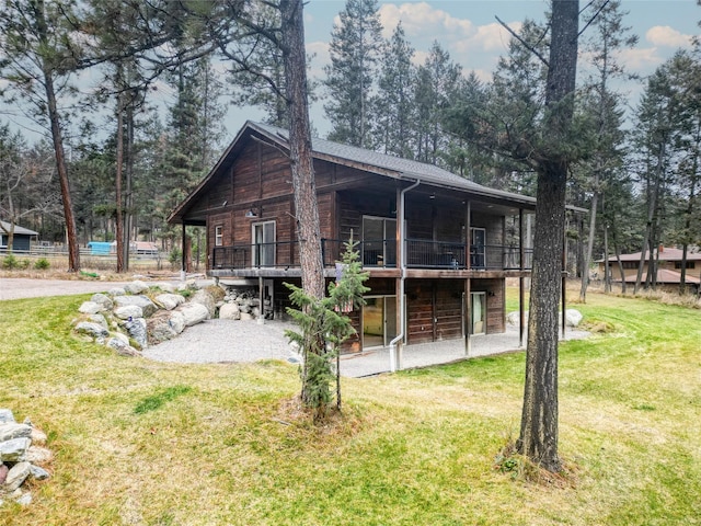 back of property featuring a deck and a lawn